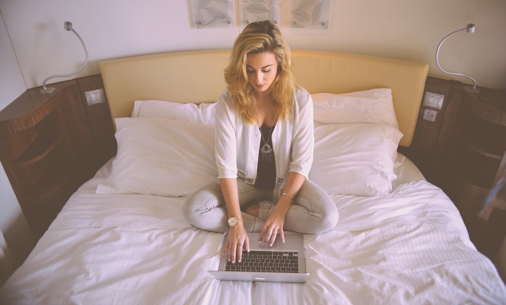 girl using a laptop on bed